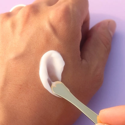 Ageless Enriching Renewal Cream texture applied on hand with gold spoon